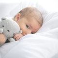 Baby im Kinderbett mit Bettwäsche von Träumeland