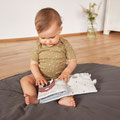 Baby mit Activitybuch auf Krabbeldecke