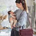 Mutter mit Baby auf dem Arm und Umhänge- Kinderwagentasche von LÄSSIG