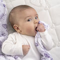 Baby mit Schnuffeltuch im Babybett
