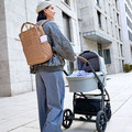 Mama mit Rucksackund Kinderwagen