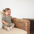 Fröhliches Mädchen in Sofaecke sitzend