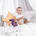 Baby im Kinderbett mit Kuschelzubehör