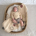 Baby im Babykorb mit Schmusedecke