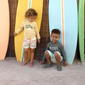 Kinder in Badehosen mit Schwimmwindel von LÄSSIG stehend und sitzend vor Surfboards
