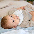 Baby mit LÄSSIG Bandana auf Wickelunterlage