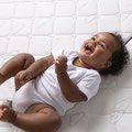 Lachendes und strampelndes Baby auf Träumeland Matratze