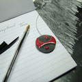 mise en scène d'un collier en céramique raku rouge et noir