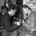 Charles Pater en Rudi Contini Selier (de gitarist van Pim Maas) wisselen gitariteiten uit tijdens de finale van de Elvis wedstrijd in de Royal. Op de achtergrond kijkt Roek Williams = Willemze (met Buddy Holly bril) toe.