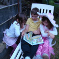 Dimitri faisant la lecture à ses cousines Justine et Marine