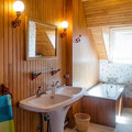 Salle de bain à l'étage avec grande baignoire sous pente et double vasque.