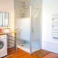 Salle de bain moderne au rez-de-chaussée avec douche à l'italienne, vasque et lave-linge.