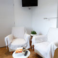 Espace de détente intime et calme avec deux fauteuils confortables, un coin lecture et une télévision.