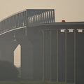 "rotes Fahrzeug auf Hochbrücke" von Wolfgang