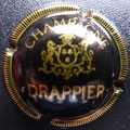 Marque : DRAPPIER N° Lambert : 2 Couleur : Noir, petit écusson.  Description : Inscription Drappier sur armoiries surmontée d'une couronne et soutenue par deux lions  Emplacement : 