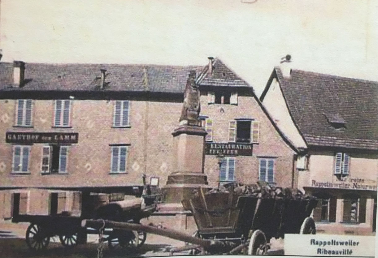Place de la Sinne à Ribeauvillé, sur la droite affiche annonçant ne commercialiser que des "Rappoltsweiler Naturwein" c'est à dire des "vins nature" de Ribeauvillé - Photographie : Cercle de recherches historiques de Ribeauvillé et environs, revue N°22