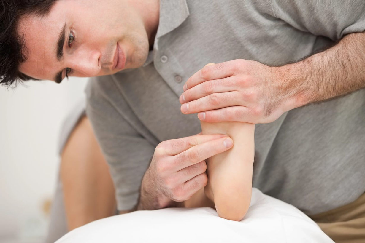 Senmotic Therapeut behandelt die Plantarfaszie am Fuß mit seinen Fingern