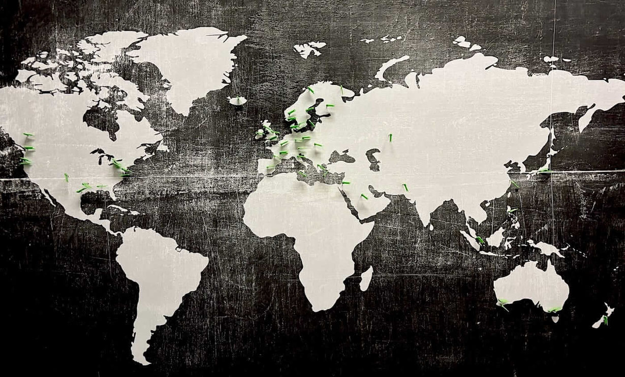 Weltkarte mit grünen Fähnchen als Synonym für Senmotic Kunden