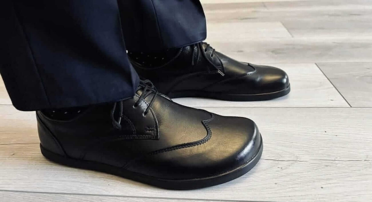 Senmotic Barfußschuhe als schwarze Businessschuhe aus feinem Rindsleder mit schwarzen Senkeln getragen zu einem dunkelblauen Anzug 
