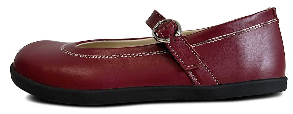 Ballerina aus rotem Glattleder mit Riemen und silberner Schnalle. Mit weißen Nähten und schwarzer Sohle und beigen Innenfutter. 
