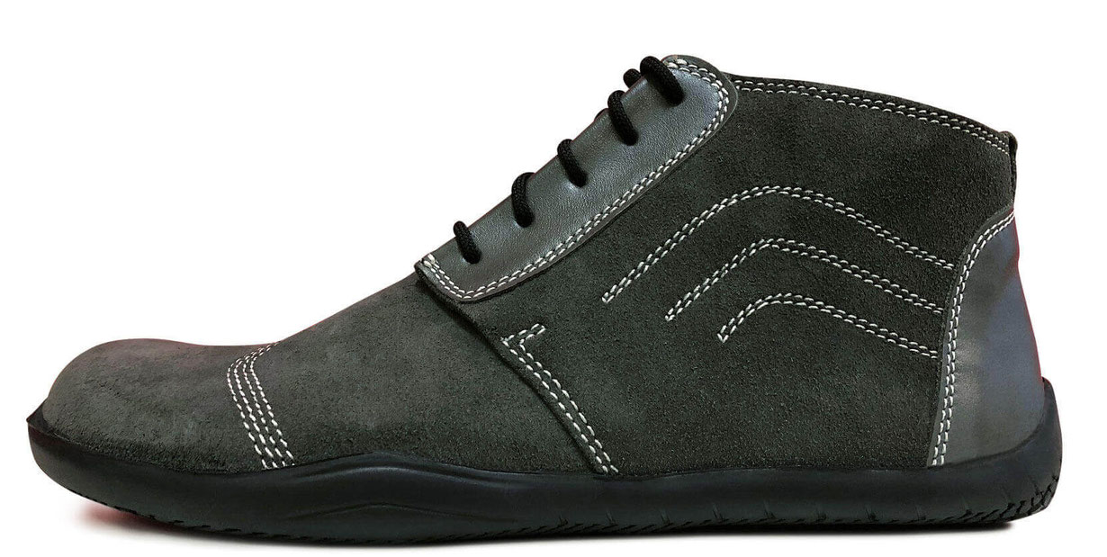 Knöchelhoch geschnittener Barfußschuh komplett aus grauem Veloursleder mit weißen Nähten einer schwarzen Laufsohle und schwarzen Senkeln