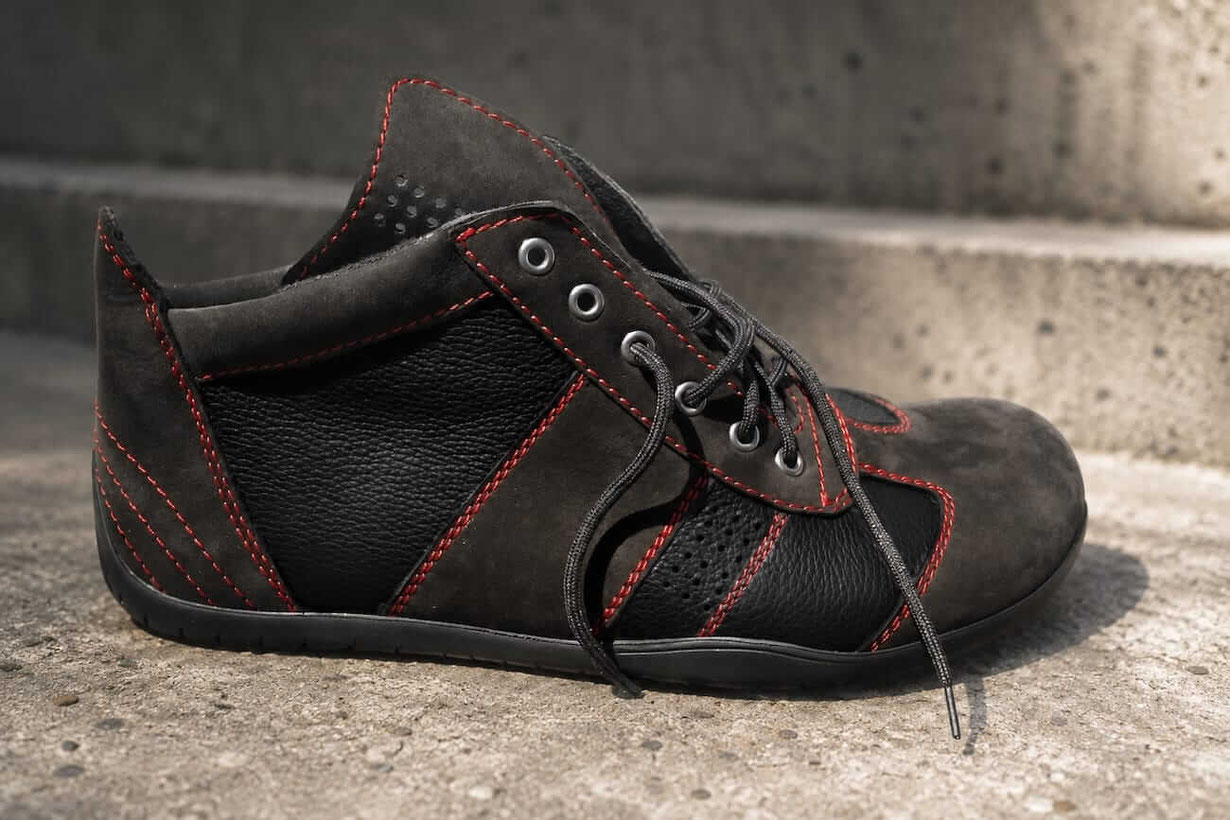 Barfußschuh aus schwarzem Rindsleder mit schwarzem Veloursleder und roten Kontrastnähten