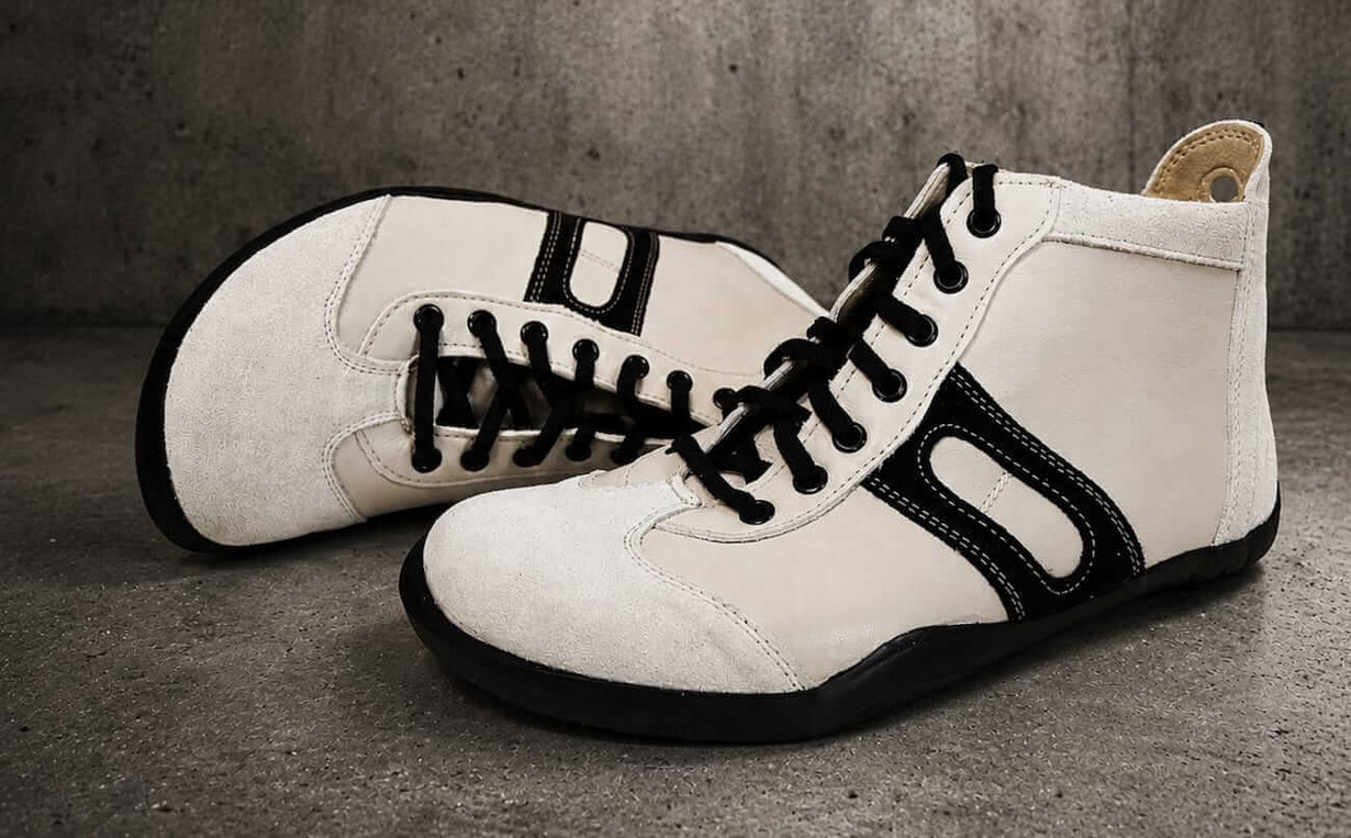 Knöchelhohe Barfußschuhe aus cremefarbenen Leder mit schwarzen Senkeln und beigen Innenfutter