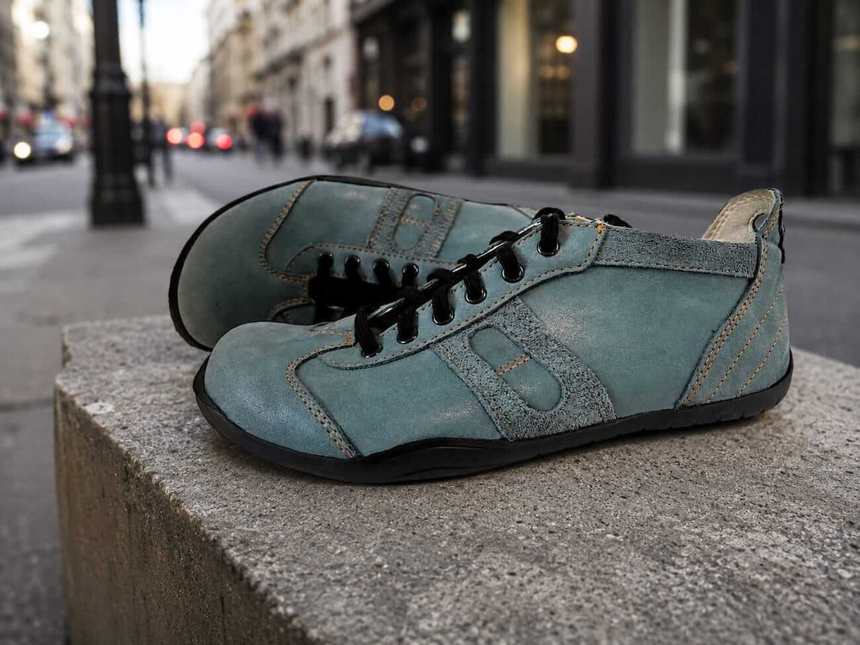 Barfußschuhe aus petrolfarbenen Leder mit schwarzen Senkeln und beigen Innenfutter