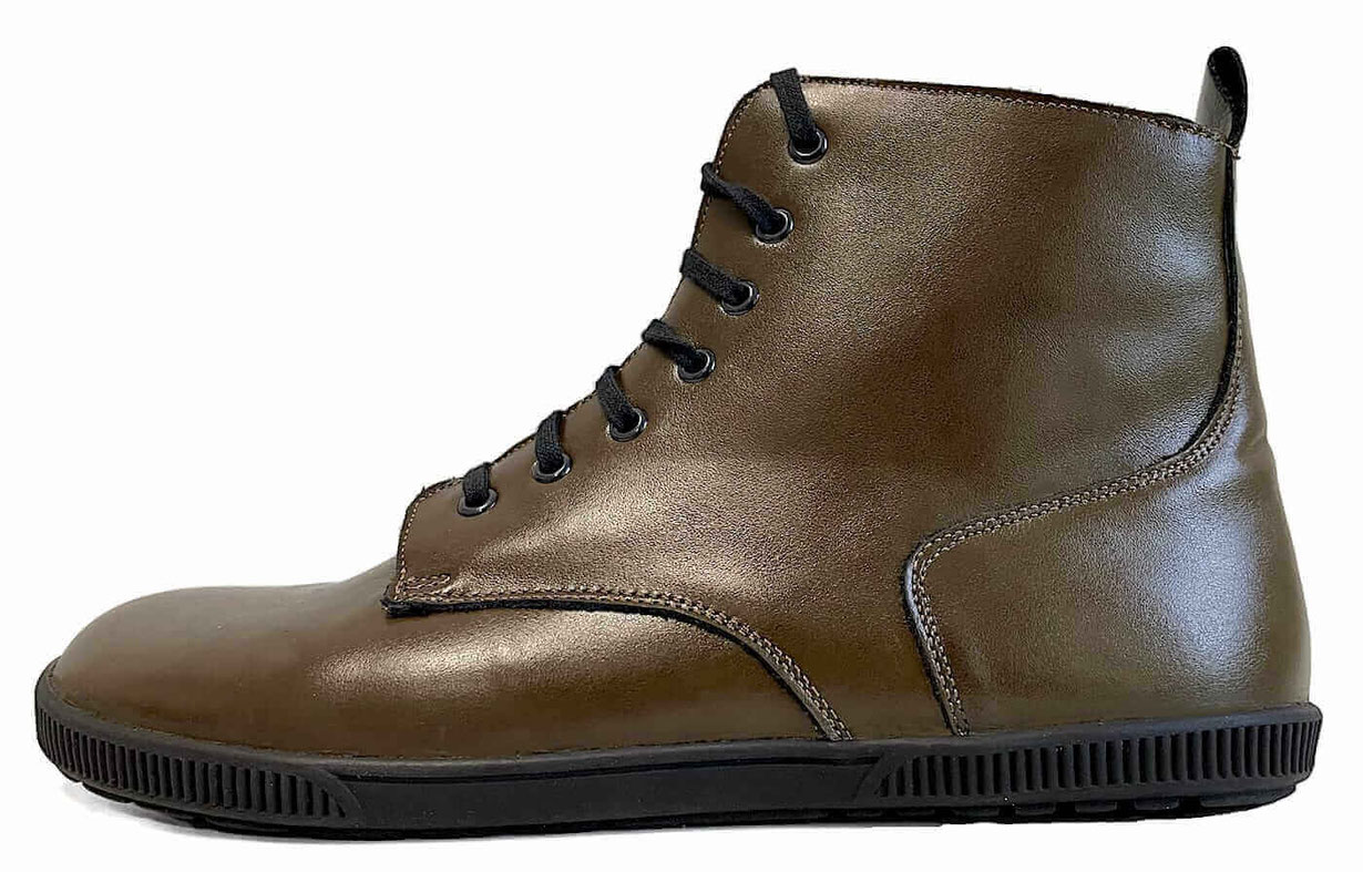 Barfußschuh als Winterstiefel aus grünem Glattleder mit camelfarbenen Nähten und grob profilierter Sohle, schwarzen Senkeln und schwarzen Lammfell