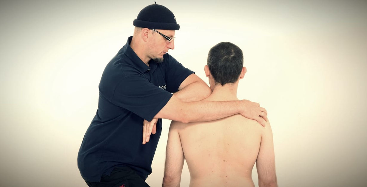 Faszien Therapeutin arbeite mit den Händen am Rücken einer Patientin