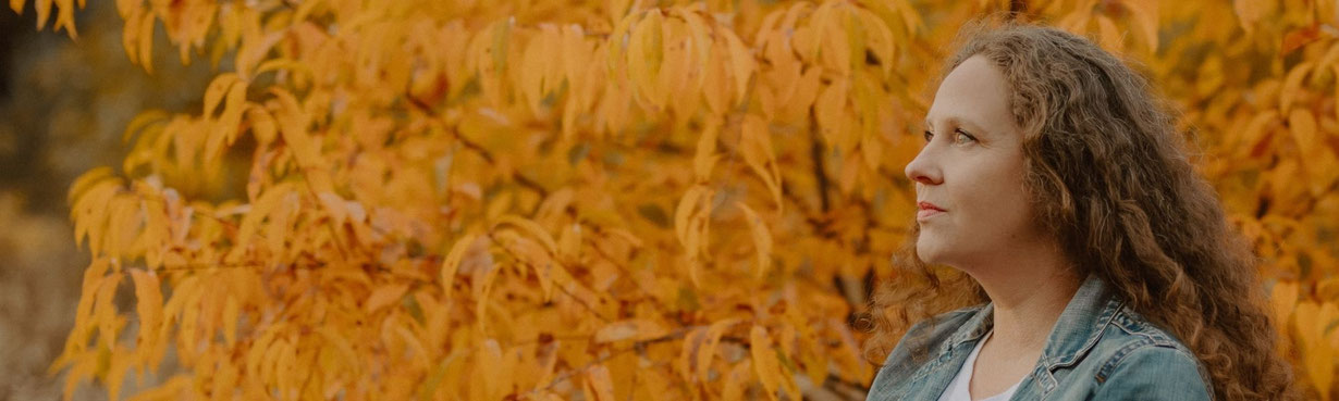 Verkörperte Präsenz im Übergang – eine Frau in stiller Rückverbindung zu ihrer inneren Kraft.