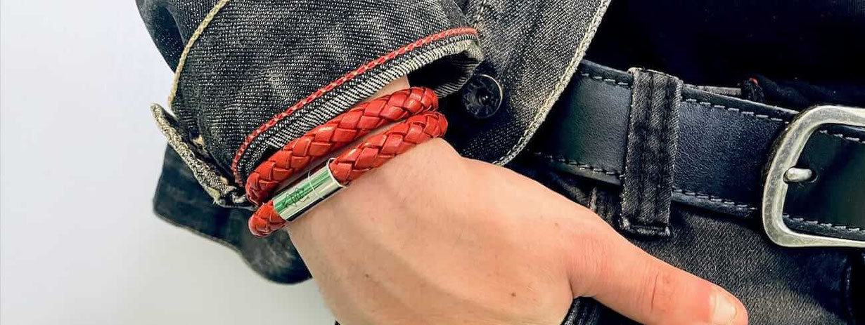 Doppeltes rotes geflochtenes Lederarmband mit Edelstahlverschluss am Handgelenk eines Mannes
