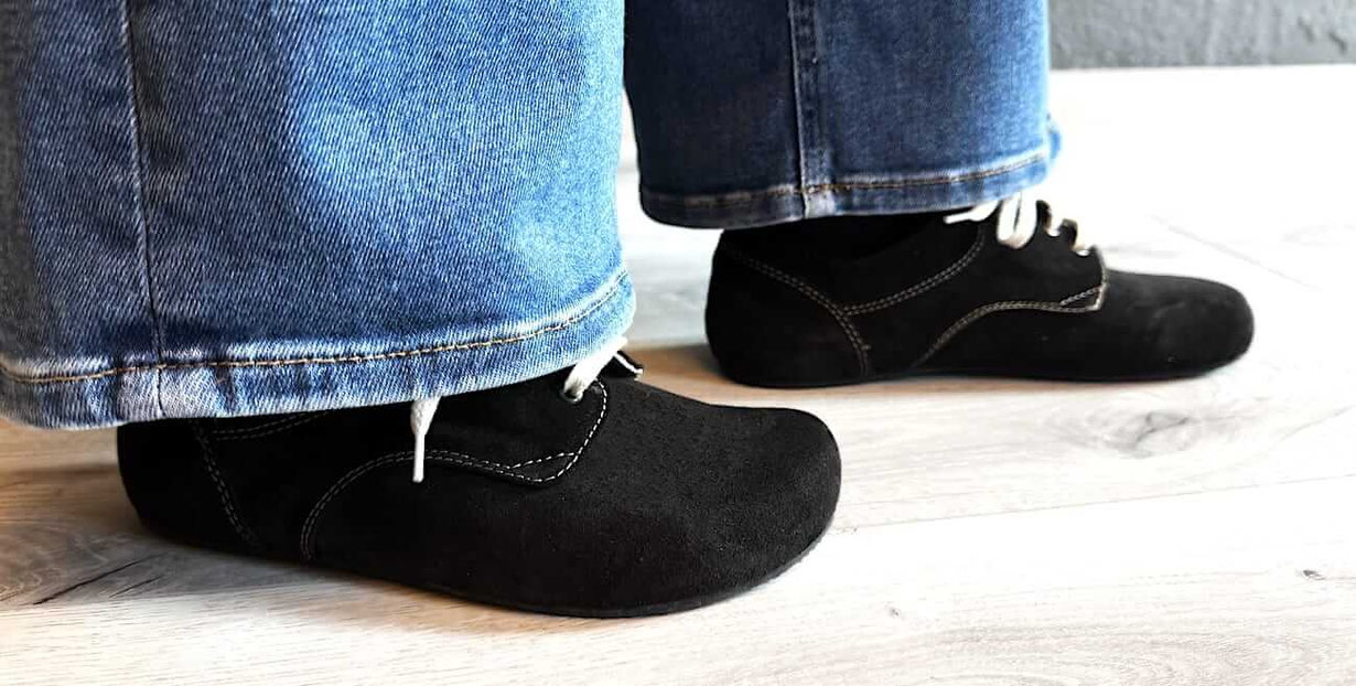 Pure Barfußschuhe Wildleder Schwarz mit weißen Nähten getragen zur blauen Jeans