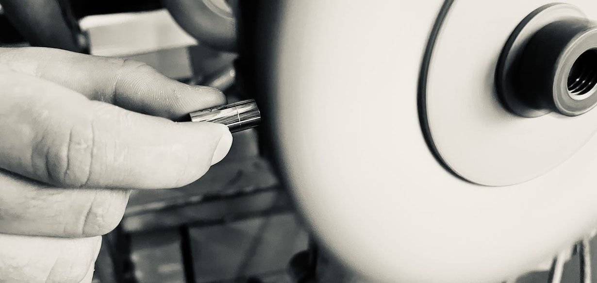 Ein Edelstahl Magnetverschluss für Armbänder wird mit der Hand an eine schnell drehende Polierscheibe einer Maschine gehalten