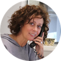 Portraitfoto von Ansprechpartnerin Heike Löcker mit Telefonhörer am Ohr