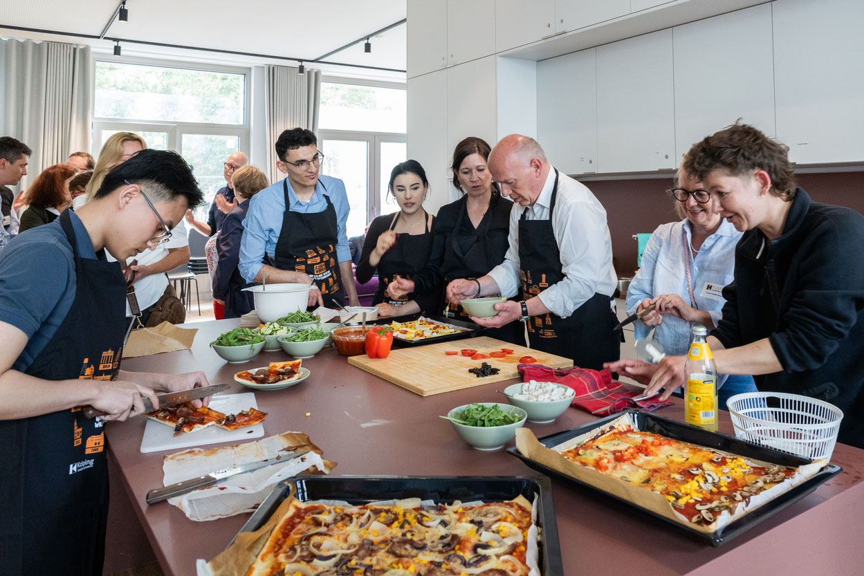 Berlins Regierender Bürgermeister Kai Wegner (3.v.r.) und Bildungssenatorin Katharina Günther-Wünsch (4.v.r.) kochen und diskutieren mit Jugendlichen im neuen Kolping Jugendwohnen Berlin-Mitte. Foto: Ines-fotografie.Berlin / Kolping Deutschland