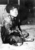 米軍の爆撃でとり残された男の子。難を逃れるため女の子の格好をしている