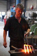 Schmiedemeister F. Sneeboer bei der Arbeit