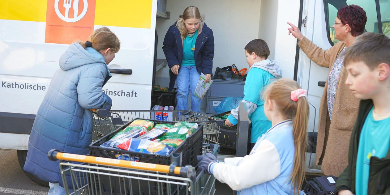 Schülerinnen und Schüler aus Wittlich laden gesammelte Lebensmittel in den „Tafel“-Transporter. © Imran Ahmad Zafar