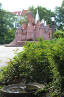 Vogeltränke und zwischen alten Bäumen der Fruchtbarkeitsbrunnen mit hohen Wasserfontainen. Arnswalder Platz. Foto: Helga Karl