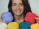 Florence, tête souriante parmi des pelotes de coton colorées