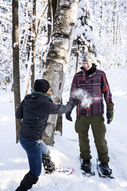 Photo of two colleagues having a snowball fight in winter during a team-building event in the Eastern Townships of Quebec for Évasions Canadiana by Marie Deschene photographer for Pakolla