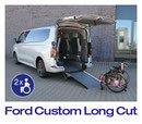Silberner Ford Custom L2 mit Long Cut Heckausschnitt. Ein Rollstuhl steht vor der Rampe, bereit zum Einfahren.