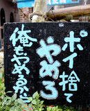 30センチメートル四方の木製の看板。ユーモラスなメッセージでポイ捨てを呼びかける=やいま大通り