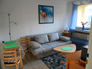 Wohnzimmer mit Schlafcouch und Balkon