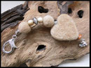 DA 34: Fellperlen und ein Fellherz mit Natur und silberperlen verziert, als Abschluss eine kleine silberne Pfote. Preis: 40 Euro