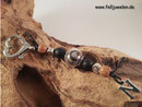 DA 18: Die Haare sind eingefasst in eine 16mm grosse Glasperle. Verarbeitet sind schwarze Onyxperlen, silberne Herzperlchen und Kokosperlen. Als Abschluss ein Buchstabe aus Edelstahl. Preis: 35 Euro