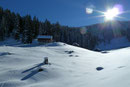 Die in die idyllische Winterlandschaft eingebetteten urigen Hütten dieser Alm gaben sich erst einige Meter oben zu erkennen.