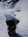 Auf der sonnenabgeneigten Seite war die Schneedecke noch immer beachtlich und das Bächlein suchte sich seinen Weg durch diese.