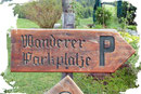 Gleich neben der hiesigen Infotafel wies ein uriges Holzschild nochmals auf den großzügigen Wanderparkplatz hin.